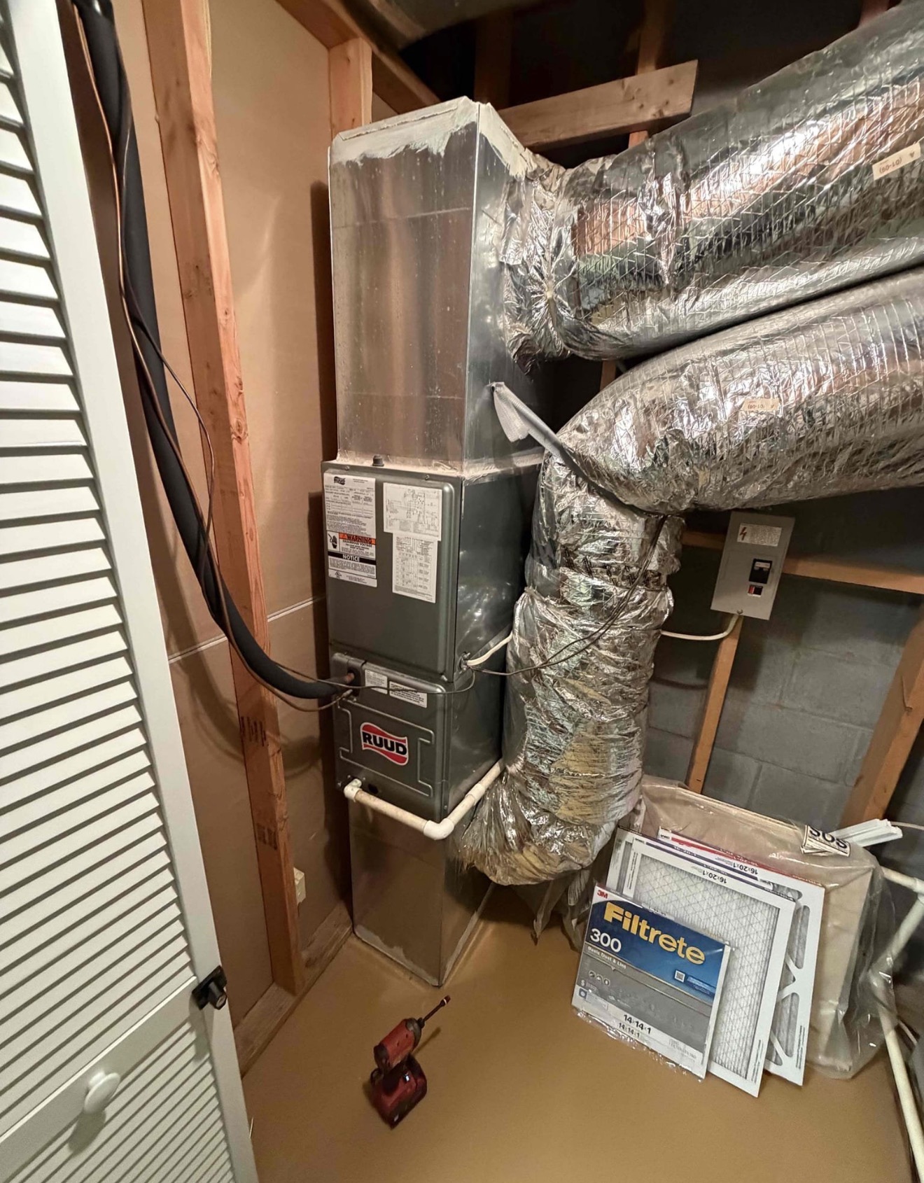 Clean Ruud air handler installed in interior closet with proper ductwork connections, insulated flex duct, PVC condensate drain, and new Filtrete 300 media filters