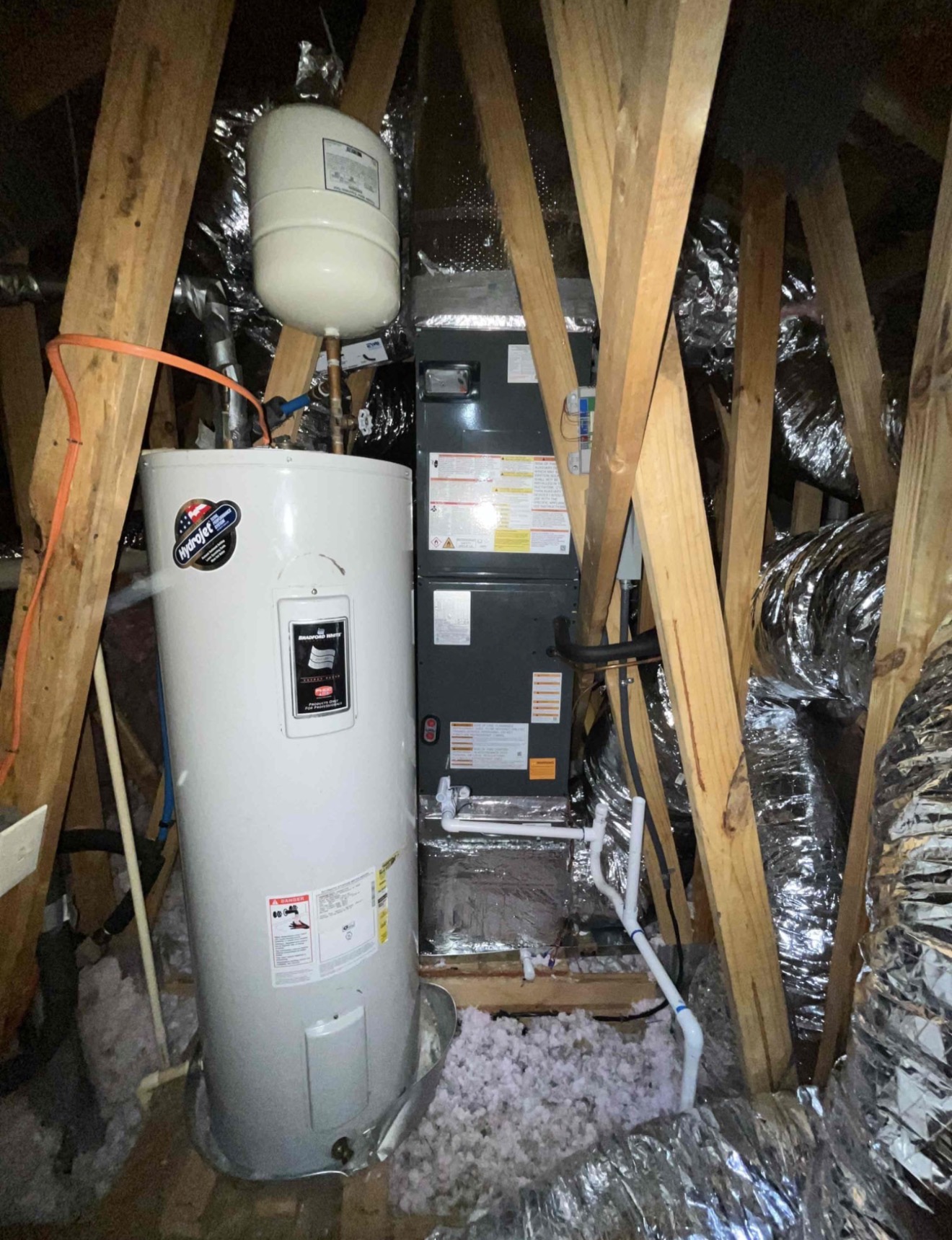 New Goodman air handler installed in attic mechanical space with insulated flex ductwork branching to supply runs, proper clearances maintained